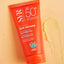 Orange sunscreen tube with SPF 50+ on a beige background